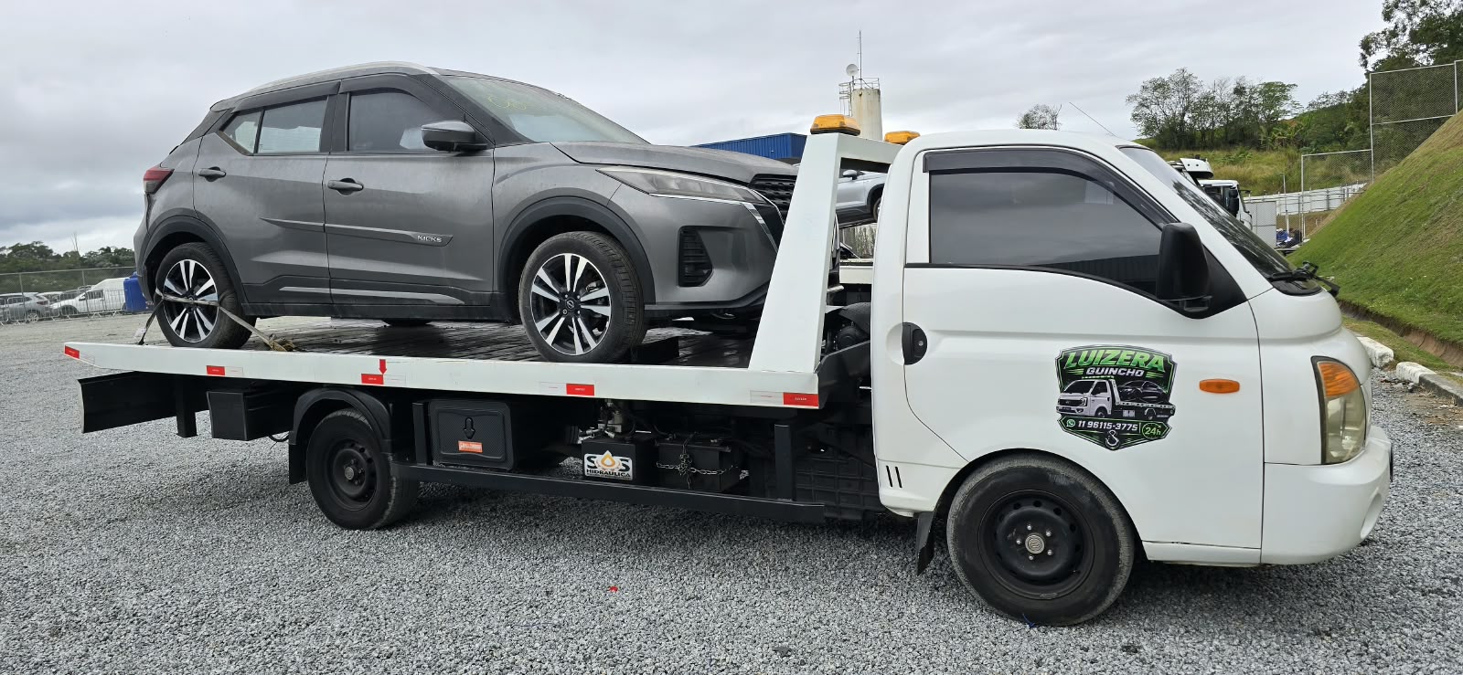 Guincho plataforma da Luizera com um SUV cinza carregado em dia nublado
