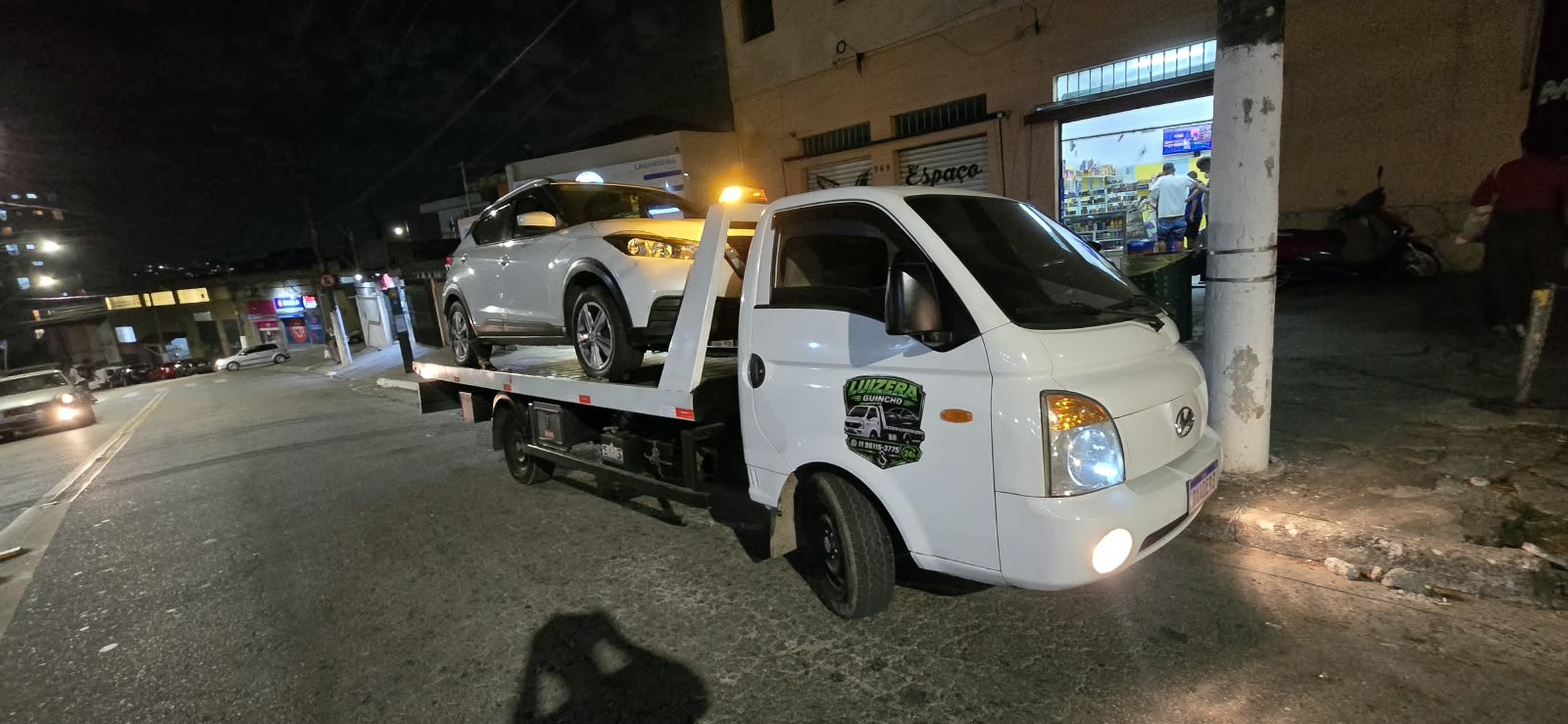 Guincho da Luizera em atendimento noturno com SUV prateado na plataforma