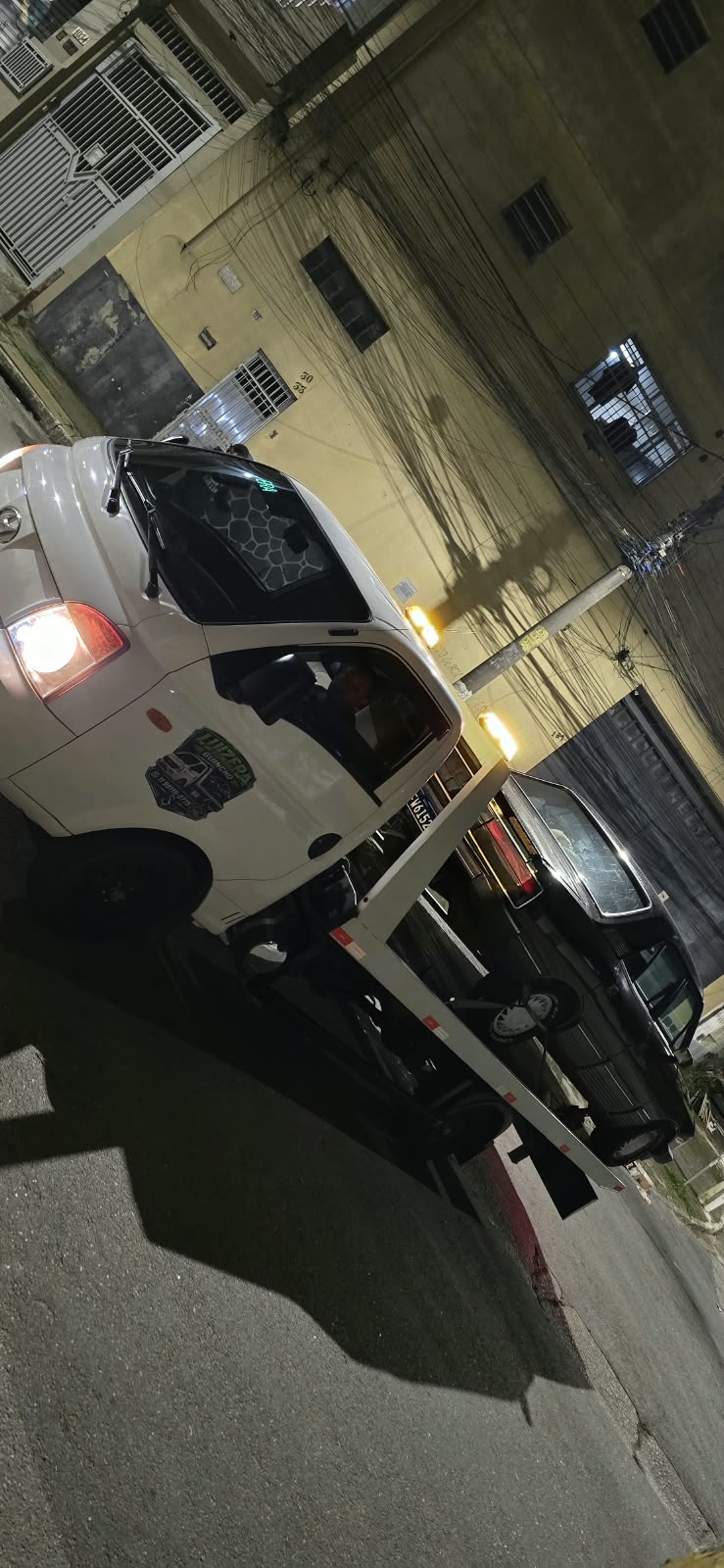 Guincho da Luizera em atendimento noturno carregando um carro escuro